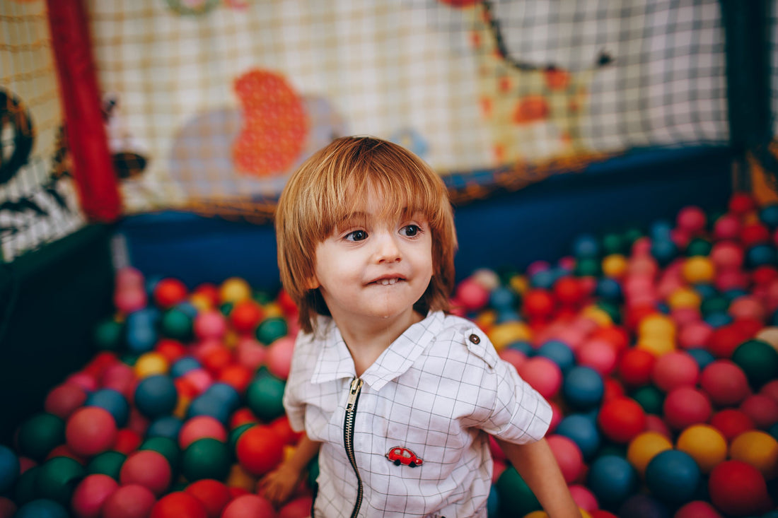 Child playing in a colorful home ball pit