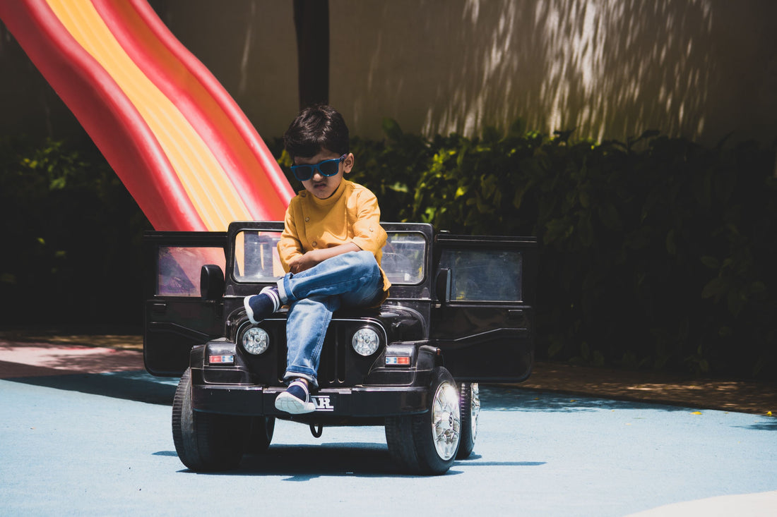 Child riding an electric ride-on toy car outdoors